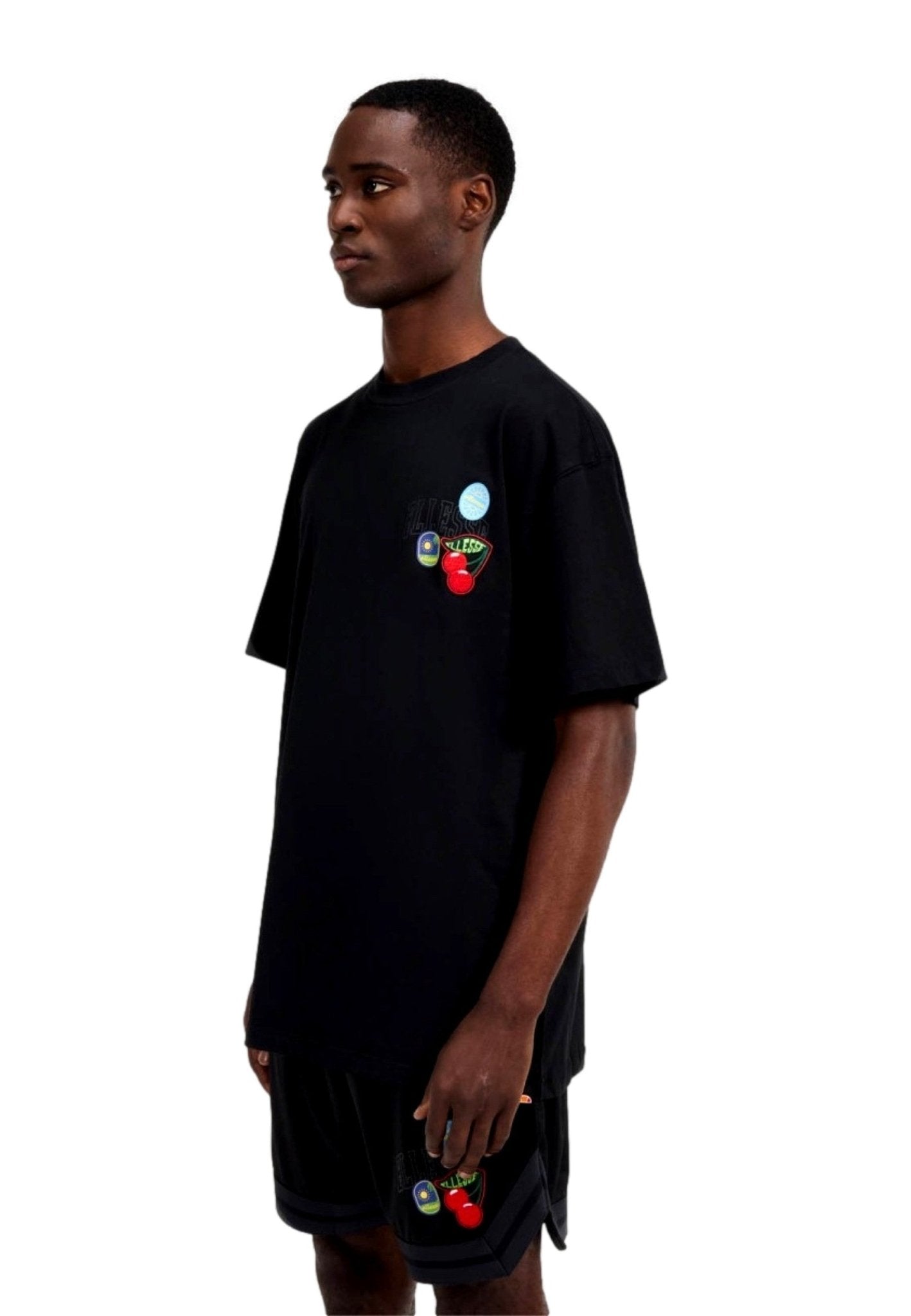 CAMISETA ELLESSE NEGRA PARCHES STICKERO TEE - AREA ZERO